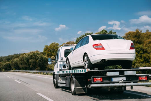 White car on flatbed truck